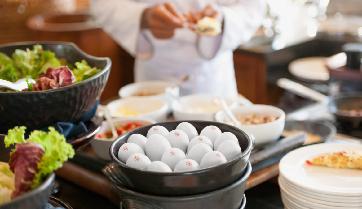 Photo of a bowl of eggs sitting within a professional kitchen.